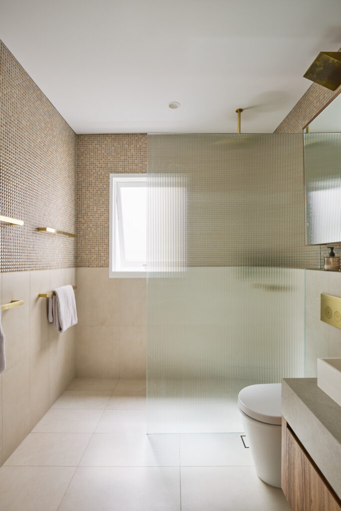 Bathroom renovation, hand made Japanese mosaic wall tile, brass tap ware, custom designed bathroom vanity and fluted shower screen designed by ACP Studio Interior Design in Redfern, Sydney.