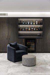 New build custom designed bar joinery with dark oak timber veneer and black marble designed by ACP Studio Interior Design in Epping, Sydney.